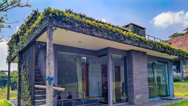 A modern house with a glass facade, a covered porch, and a staircase leading to the entrance. - Tea Garden Resort (Sagalaherang)