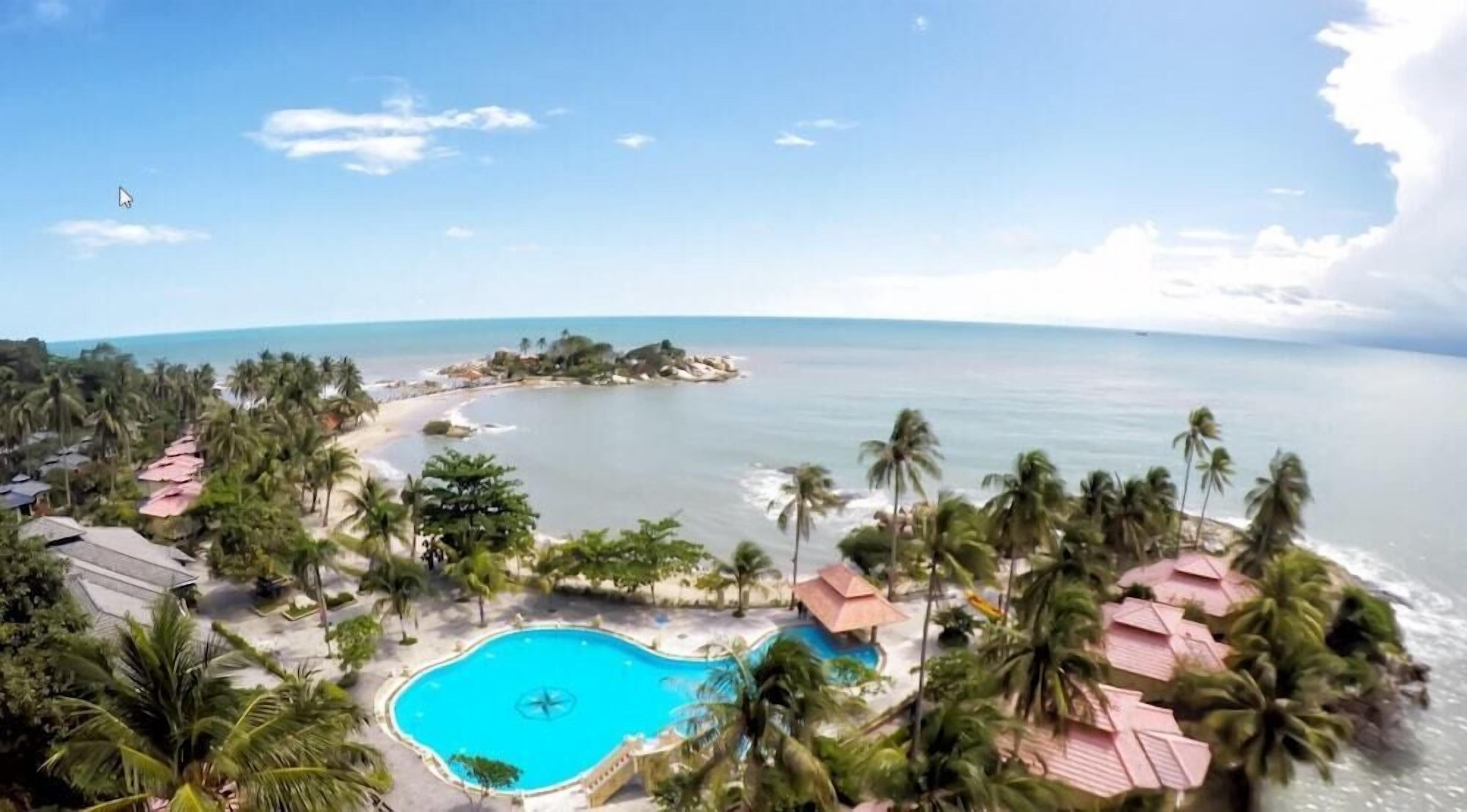 A resort with a swimming pool, palm trees, and a beach.
