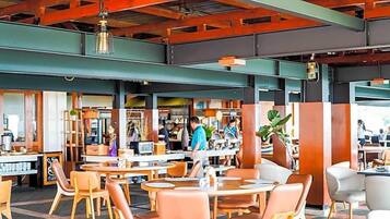 An indoor dining area with tables and chairs, a counter with staff, and a visible kitchen area.