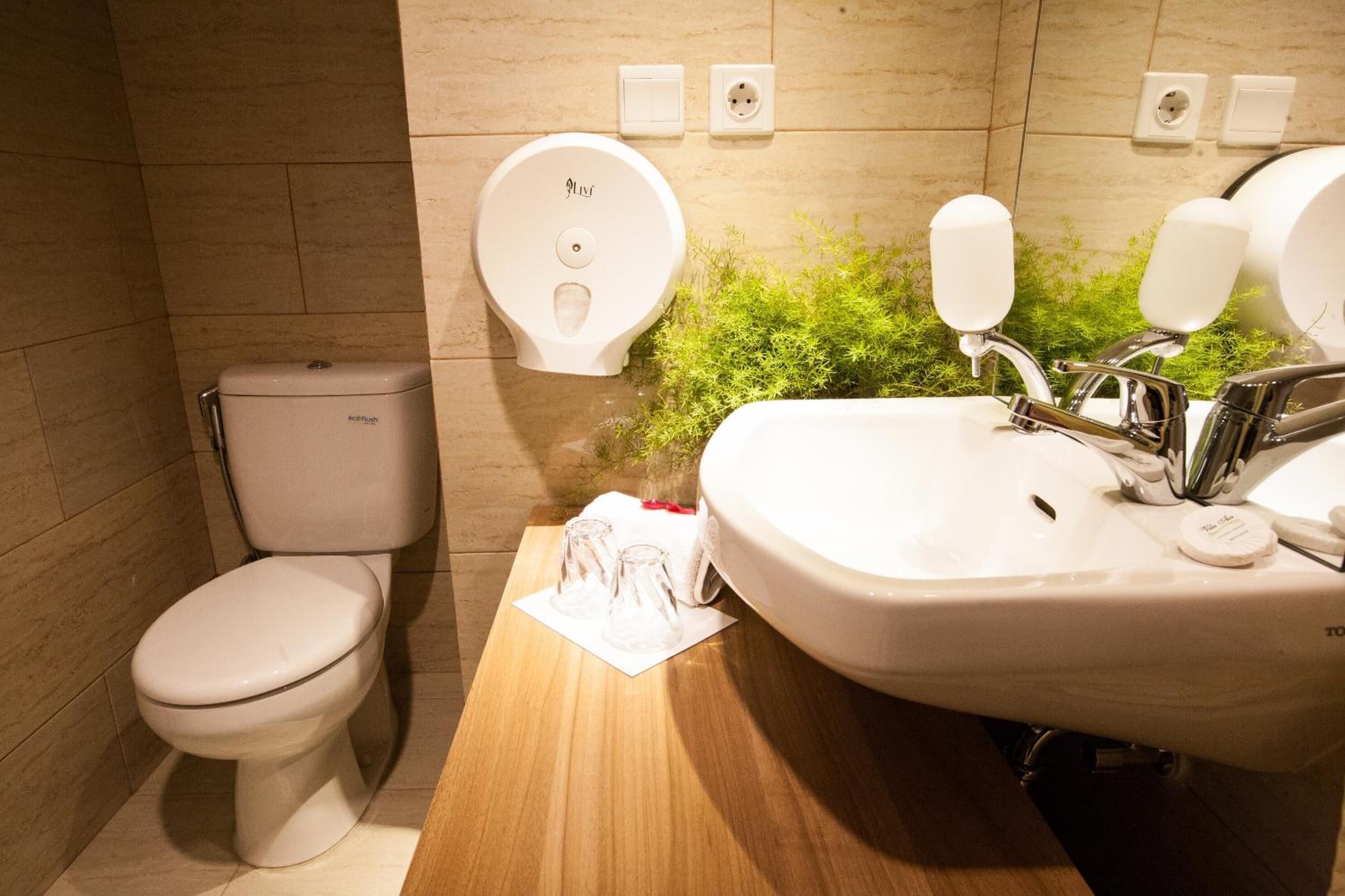 A modern bathroom with a toilet, bidet, and sink.