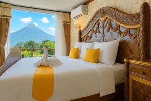 Habitació d'hotel amb un llit, un panell de fusta al capçal i vista a una muntanya.