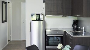 Una cocina moderna con horno integrado, cafetera y refrigerador.