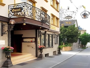 Ein Hotel mit Balkon, Schild und Blick auf die Straße.