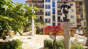 A courtyard with a statue, a multi-story building, and a stone pathway. - Woertz Schlosschen Zur Weinsteige (Stuttgart)
