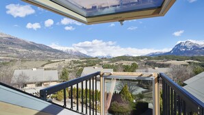 A view from a balcony with a skylight, overlooking a mountainous landscape with houses and a clear sky. - Vacances Bleues Club Les Horizons Du Lac (Chorges)