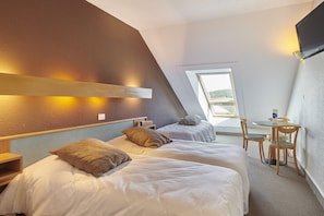 A bedroom with two beds, a small table, and a chair, a window with a view, and a TV mounted on the wall. - Vacances Bleues Club Les Horizons Du Lac (Chorges)