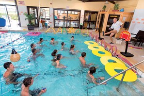 Una piscina con varias pistas de natación, sauna y canasta de baloncesto.