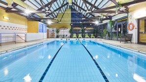An indoor swimming pool with a tiled floor, a wooden ceiling structure, and a sunroof. - Vacances Bleues Club Les Horizons Du Lac (Chorges)