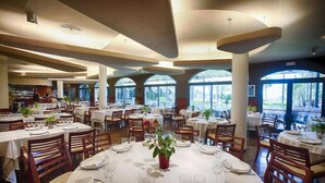 A spacious restaurant with multiple dining areas, large windows, and a modern ceiling design. - Relais Du Silence Miami Mar (Sant Carles de la Rapita)