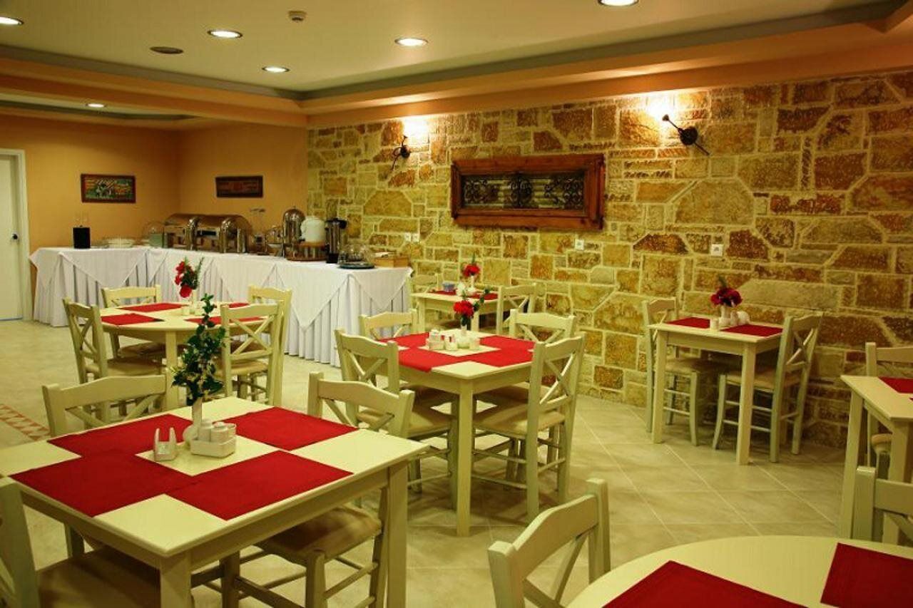 A dining area with tables set for service, stone walls, and a buffet in the background.