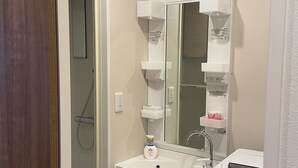 A bathroom with a shower, sink, and mirror. - Minowa Station Hideaway - Breakfast + Free Coffee & Tea (台東区)