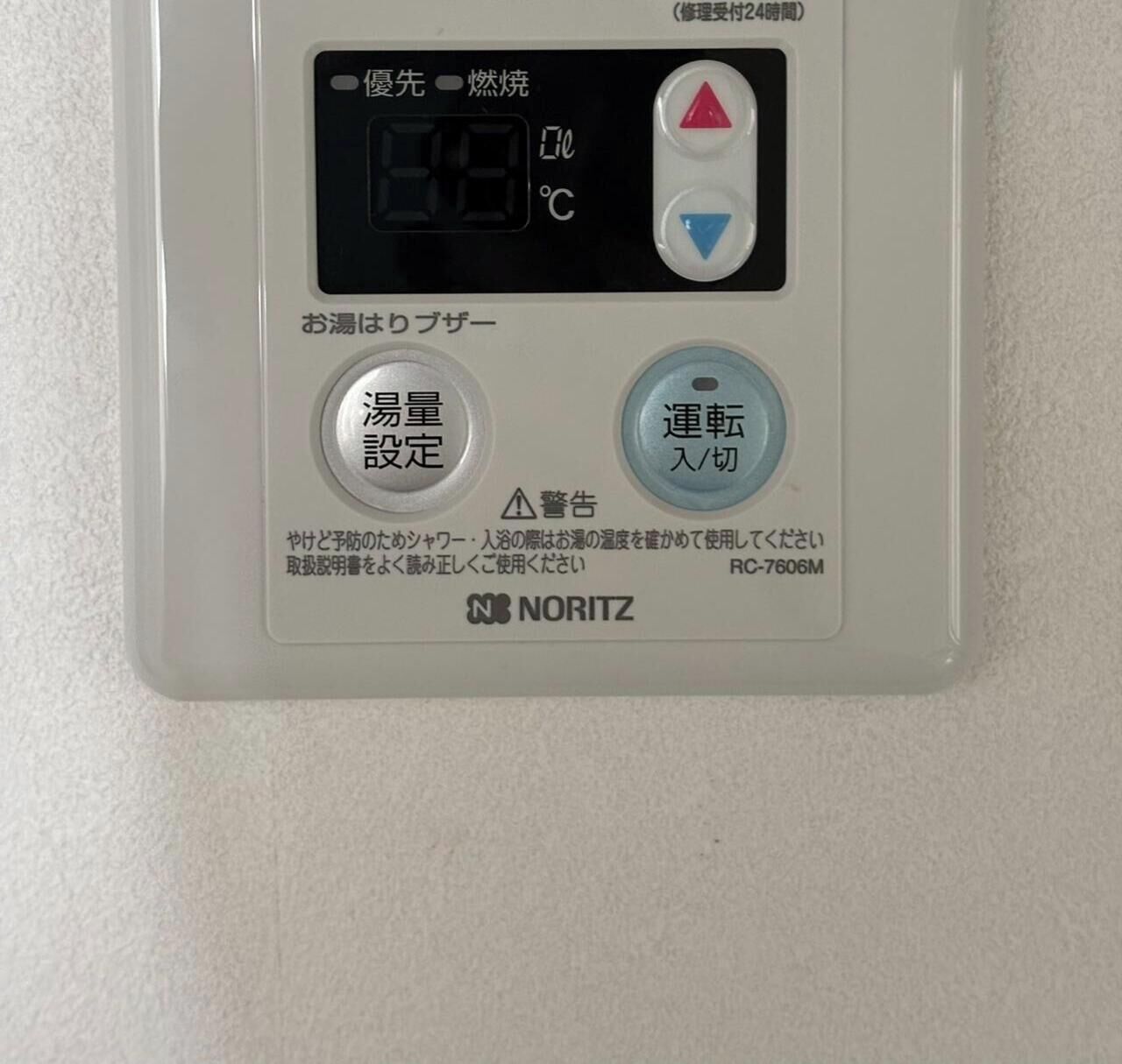 Panel de control de calentador de agua NORITZ con ajustes de temperatura y botones de funcionamiento.