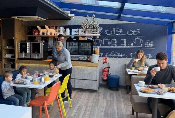 A modern cafe with a chalkboard menu, wooden shelves, and a fire extinguisher. - Premiere Classe Lyon Nord Dardilly (Dardilly)