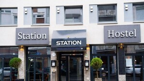 Un bâtiment portant des panneaux indiquant « Gare » et « Auberge », ce qui signale la présence d’options d’hébergement.