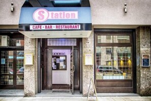 Un café, bar y restaurante con un letrero sobre la entrada.