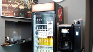 Un mini-bar comprenant un réfrigérateur, une horloge et une machine à café.