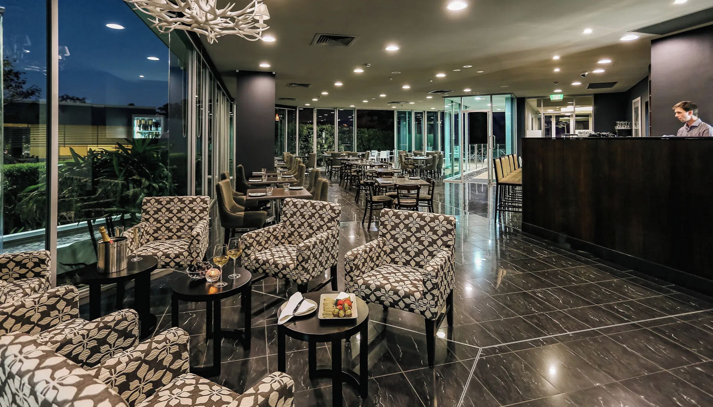 Un espace intérieur spacieux, aménagé avec différents types de sièges, notamment des canapés et des fauteuils, ainsi qu’un comptoir d’accueil.