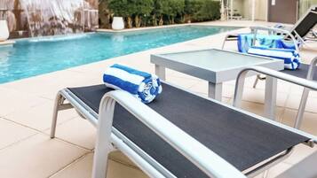 A poolside area with lounge chairs and a small table.