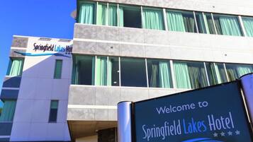 Un letrero de hotel con el nombre 'Springfield Lakes Hotel' y un mensaje de bienvenida.