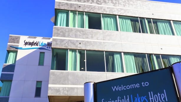 Un letrero de hotel con el nombre 'Springfield Lakes Hotel' y un mensaje de bienvenida.