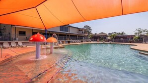 Una piscina con agua cristalina, rodeada de tumbonas y sombrillas.