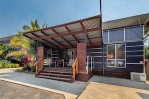 A modern building with a covered entrance, outdoor seating, and a staircase leading to the entrance. - Sydney Getaway Holiday Park (Sydney)