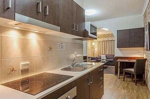 Una cocina moderna con una isla central, armarios empotrados y una zona de comedor con sofá y mesa.