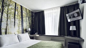 A hotel room with a bed, a window with curtains, a wall-mounted TV, and a bedside table with a lamp. - Best Western Plus Hotel Atlant (Genk)