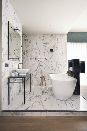 A modern bathroom with a freestanding bathtub, a vanity with a sink, and a mirror. - Best Western Plus Hotel Atlant (Genk)