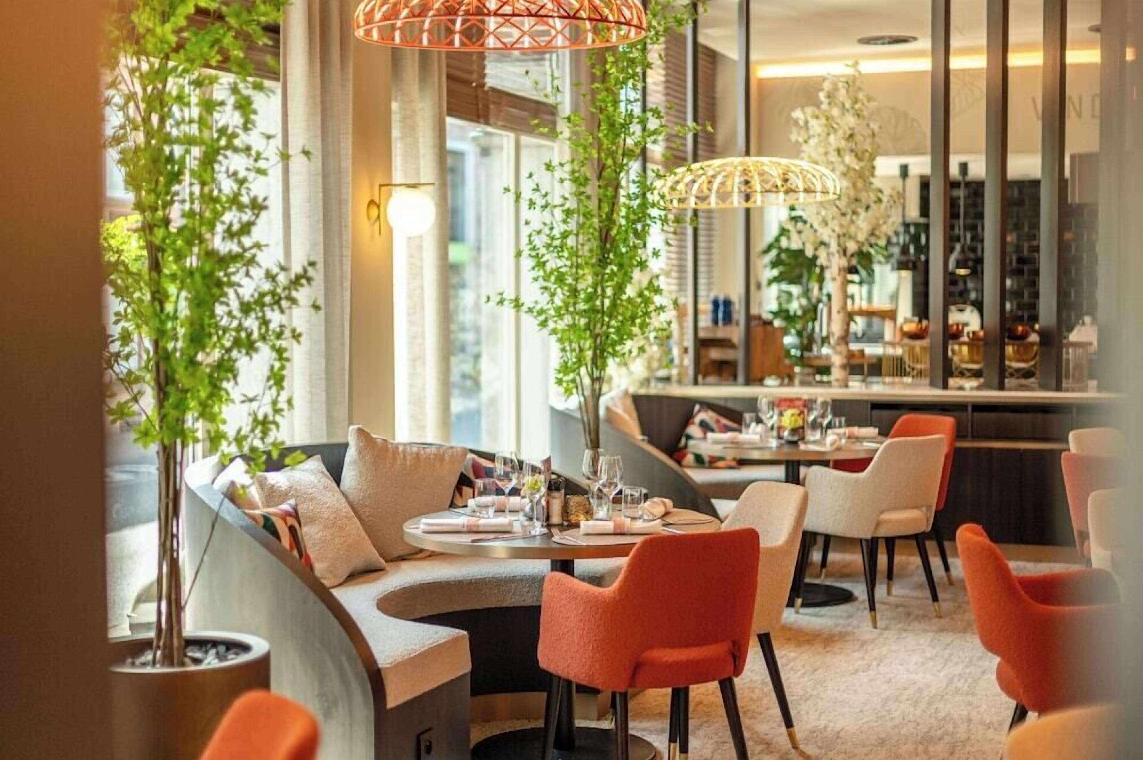 Un espace de restauration moderne avec un aménagement des sièges en arc de cercle, un comptoir de bar et un éclairage décoratif.