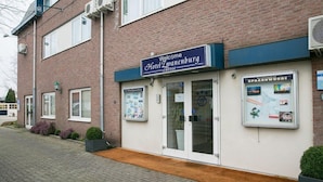 A hotel entrance with a sign reading "Welcome Hotel Zwanenburg."