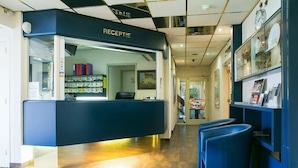 A reception area with a desk, chairs, and a glass display case.