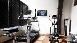 A home gym with a treadmill, elliptical, and stationary bike. - Grand Hotel De Draak And Residence Dagmara (Bergen op Zoom)