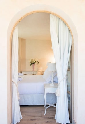 A bedroom with a bed, bedside table, lamp, and a vase with flowers. - La Villa Del Re - Adults Only (Castiadas)