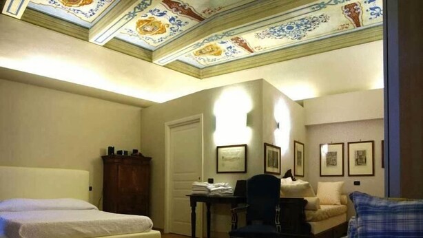 Une chambre avec deux lits, un bureau, une chaise et un canapé.