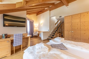 A bedroom with a bed, a desk, a chair, a TV, and a wardrobe. - Alp Holiday Dolomiti (Dimaro Folgarida)