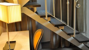 A modern staircase with a metal railing and a lamp on the left.