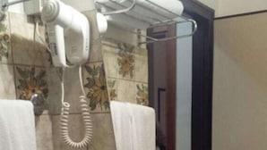 Une salle de bain équipée d’un lavabo, d’un sèche-cheveux et d’un porte-serviettes.