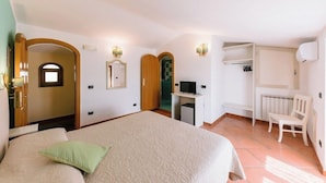 A bedroom with a large bed, a desk with a computer, a chair, and a wardrobe. - Albergo La Margherita (Scala)