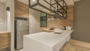 A modern kitchen with a central island, stainless steel appliances, and a wooden accent wall.