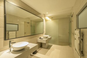 Een moderne badkamer met een grote spiegel, twee wastafels en een douchehoek.