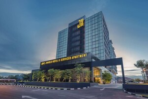 Un edificio moderno de hotel con un llamativo logotipo 'J' en la fachada.