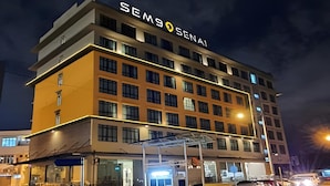 A multi-story hotel with a prominent 'SENAI' sign on the facade, featuring a modern architectural design with a flat roof and a series of windows. - Sem9 Senai (Senai)