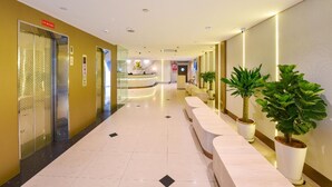 A hotel lobby with a reception desk, elevators, potted plants, and a clean, tiled floor. - Hotel Imperial (Kuala Lumpur)