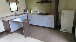 A kitchen with a built-in sink, a stove, a refrigerator, and cabinets. - Felda Residence Hot Springs (Ipoh)