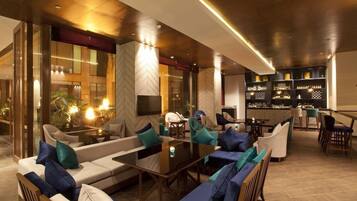A modern lounge area with sofas, chairs, and a bar.