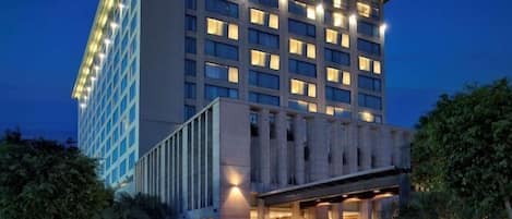 A modern hotel with a prominent entrance, multiple floors, and a well-lit facade.