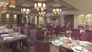 Un restaurant doté de nombreuses tables, de chaises et de lustres suspendus.