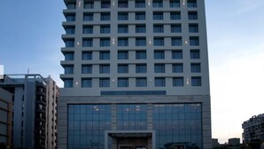 Un immeuble moderne de grande hauteur, doté d’une vaste façade en verre et de nombreux étages.