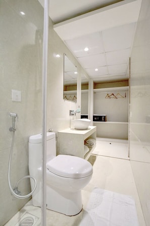 Een moderne badkamer met toilet, wastafel en douche.